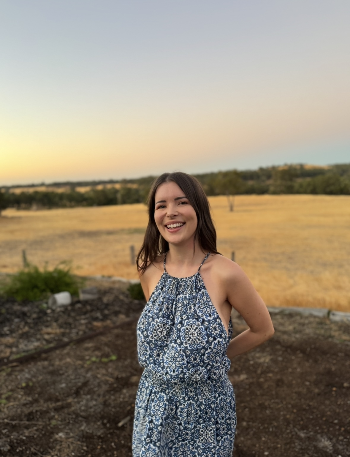 Katie, the Wildlight Kinesiology practitioner, smiling in the warm afternoon light